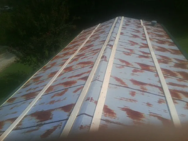 Rusted metal roof panels with new wood purlins before replacement — Storm Damage Roof Repair in Brookline by Roofing Brothers