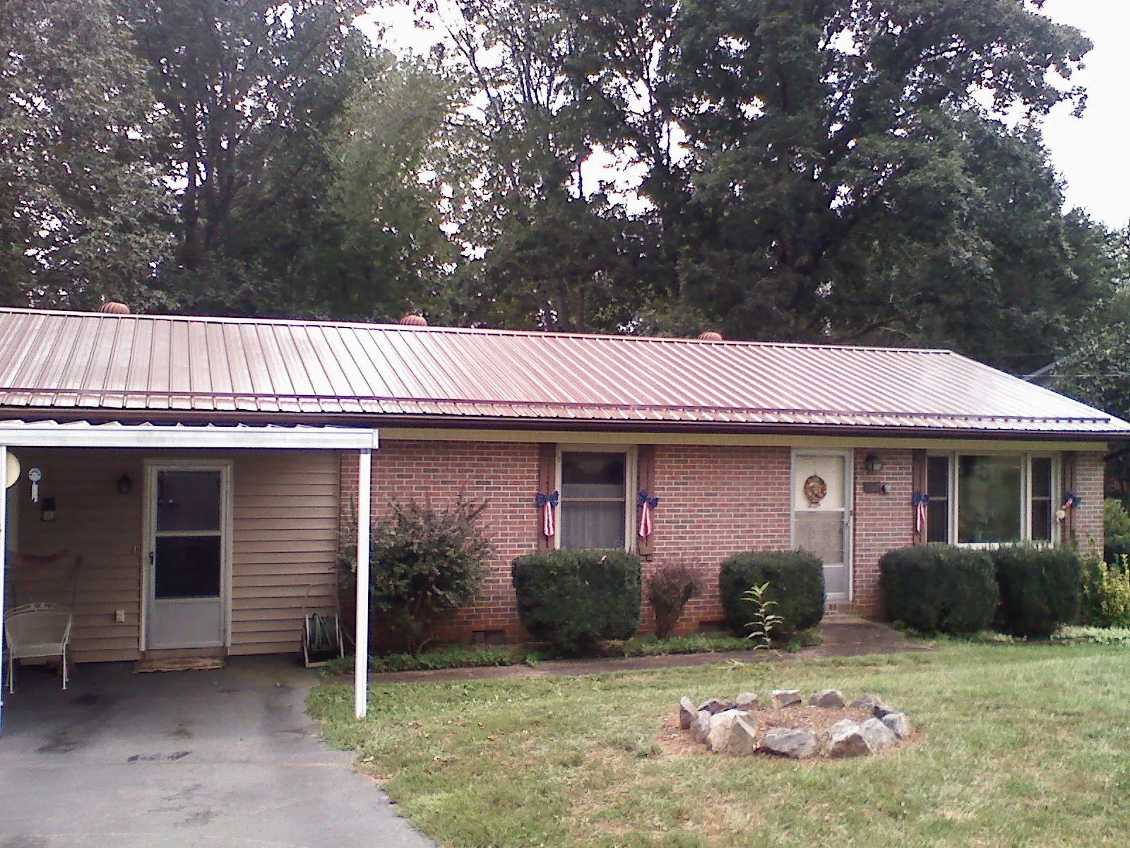 Bronze metal roof and carport on a brick ranch home — Roof Repair work by our crew in Brookline